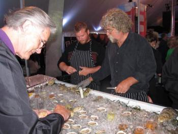 Jeff "Smokey" McKeen churns out freshly shucked Pemaquid oysters as fast as he can while people chose of two types of champagne from “The Bubble Bar” to accompany it. (Photo by Kay Stephens)