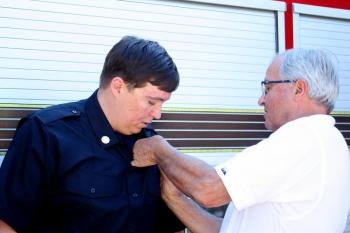 Bill Pendleton’s father, Mark Pendleton, pins on his new Rockland Paramedic badge. (Photo by Holly S. Edwards)