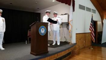 Capt. Jerry Davenport (left), gives a certification of commendation to outgoing commander officer, John Huard. (Photo by Sarah Shepherd)