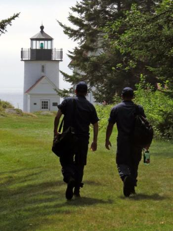 BMC Sean Dolan and MK3 Joseph Pineda, of the U.S. Coast Guard cutter Tackle, walk across Curtis Island to Curtis Island Lighthouse. (Photo by Bob Trapani)
