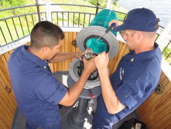 U.S. Coast Guard petty officers MK3 Joseph Pineda and BMC Sean Dolan work on replacing the lampchanger in the light at Curtis Island on July 18. (Photo by Bob Trapani)
