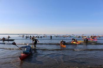 Swimmers and their paddle escorts leave the Point Lookout Beach in Northport and head toward Islesboro more than 3 miles away.
