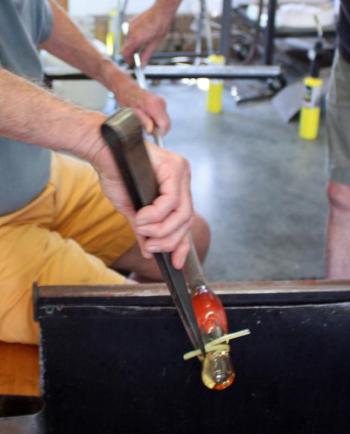 There are only seconds to work and bend the hot glass before the whole thing must be put back into the glory hole and reheated to a pliable state. (Photo by Holly S. Edwards)