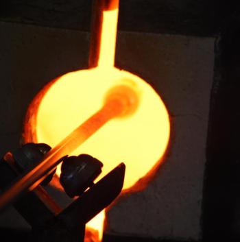 A view of the colored lip wrap inside the glory hole, being reheated so it will become hot enough to create a taffy-like strand around the top edge of the drinking glass. (Photo by Holly S. Edwards)