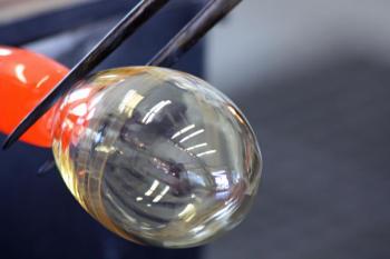 A puff of air expands the hot blob of glass at the end of the blow pipe, as a drinking glass begins to take shape. (Photo by Holly S. Edwards)
