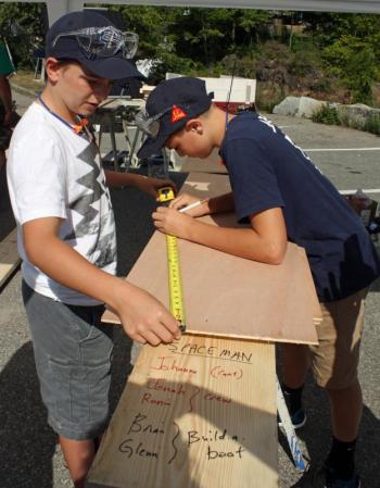 Measure twice, cut once. One of the five Build-a-Boat teams, Jonah and Ronin get to work on their boat Saturday morning. (Photo by Holly S. Edwards)