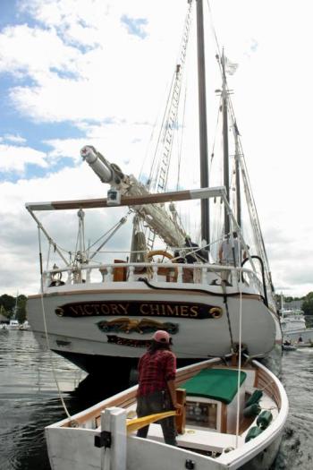 The three-masted schooner Victory Chimes takes more than a few small boats to get it nestled up to the docks in Camden Harbor Friday. (Photo by Holly S. Edwards)