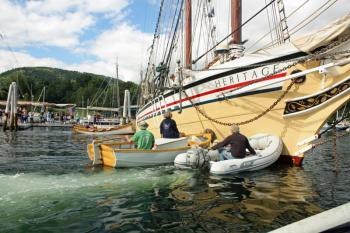 A few perfectly placed pushes are needed Friday afternoon to maneuver the schooner Heritage back into a berth on the town docks at the head of Camden Harbor at the start of the 2016 Camden Windjammer Festival. (Photo by Holly S. Edwards)