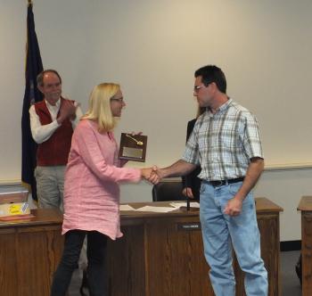 Assistant Public Services Director Christopher Donlin receives a handshake and a plaque from Mayor Louise MacLellen-Ruf for a job well done.