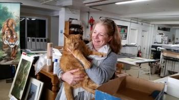 Stacey Warner, of Warner Graphics in Camden, is feeling the love as she cuddles with her new shop cat, James. (Photo by Sarah Shepherd)