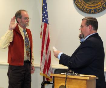 City Clerk Stuart Sylvester gives the oath of office to now senior councilor Larry Pritchett