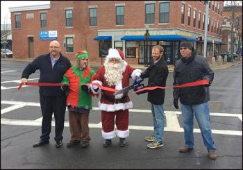Tom Peco, director of the Penobscot Bay Regional Chamber of Commerce, one of Santa’s Elfs, with Santa Claus, Rockland Mayor Will Clayton and Gordon Page, director of Rockland Main Street all cut the ribbon officially opening Main St. for holiday shopping. (Photo courtesy of WCSH)