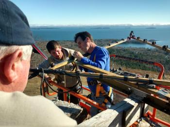 Tom Jackson, Simon Derico and Randy Stearns get the Mt. Battie Star in place high over Camden Harbor and Penobscot Bay, Nov. 19. (Photo courtesy David Walck)