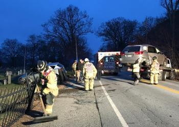 Camden firefighters sweep up glass and debris from the crash Wednesday. (Photo by Holly S. Edwards)