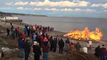 With the bonfire burning to ward off the chill, Christmas carolers sing at Lincolnville Beach, awaiting the arrival of Santa Claus. (Courtesy Andy Young)