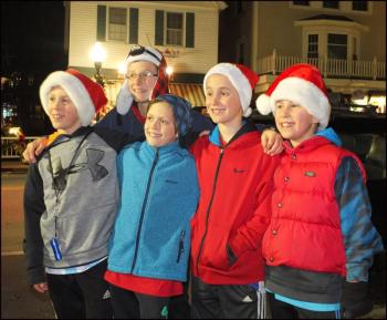 A group of kids took a minute to pose on the sidewalk before dashing off to find a choice spot to view the parade. (Photo by Chris Wolf)