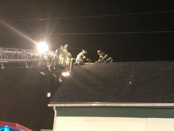 Dec. 31, 2016, Trinity Street. One Rockland firefighter works while tethered to a fire truck ladder. The other firefighter works from a suspension ladder. (Photo by Alan Athearn)