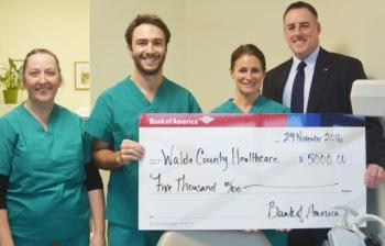 Brian King (far right), site executive for Bank of America presents a check for $5,000 from the Bank of America Charitable Foundation to representatives from Waldo County Dental Care. From left to right: Brenda Reed, dental assistant; Enrico Ross, a dental student from the University of New England who has interned with Waldo County Dental Care; Mandie Hood, dental assistant.