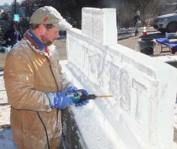 Tim Pierce, executive chef of the Samoset Resort, works on the Winterfest sign at the entrance to the Amphitheater.