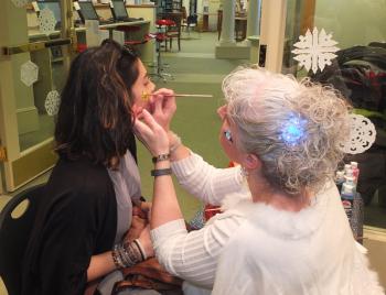 Librarian Amy Hand paints a design on Thalia Giraldo of Waterville