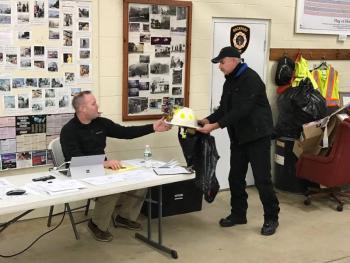 Rockport Deputy Fire Chief Todd Philbrook presents Fire Chief Jason Peasley with a custom-made Chief’s helmet, at their regular monthly meeting, to recognize his leadership since 2013. (Photo courtesy of Rockport Fire Department)