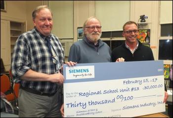 RSU 13 Superintendent John McDonald, Board Chair Steve Roberts and Tom Seekins of Siemens Industry Inc. Seekins is presenting a check for $30,000 to the RSU 13 school system. (Photos by Chris Wolf)