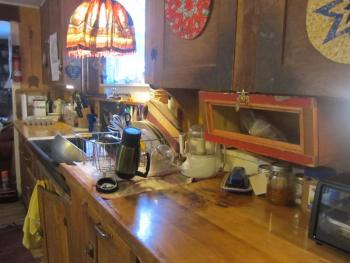 My fully-functional kitchen counter; notice that there are no mice scurrying about, nor is there a wolf spider lurking behind the faucet, the drawers slide open at a touch, and the cupboard doors latch.
Photo by Diane O’Brien kitchen