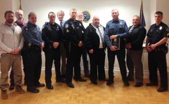 Rockport selectmen, with Camden and Rockport police officers, honor Travis Ford May 8 in Rockport. From left to right: Rockport Select Board member Owen Casas, Selectman Geoff Parker, Rockport officer Chris Taylor, Camden officer Tim Davis, Rockport Town Manager Rick Bates, Camden Police Sgt. Dan Brown, Rockport Select Board Chairman Bill Chapman, Rockport Police Sgt. James Moore, Rockport Police Officer Travis Ford, Camden-Rockport Police Chief Randy Gagne, and Camden Police Sgt. John Tooley.