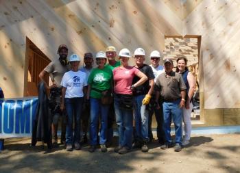 Habitat for Humanity RV Care-A-Vanners pose with fellow volunteers July 19, in front of the Waldo County affiliate’s latest build, located in Searsport. (left to right) Alex Sonnenmoser, Pam Lurz, Luke Hennings, Dottie and Chris Thompson, Andrea and Charles Putnam, Rick Gatewood, construction manager Jenness Robbins, and Meg Klingelhofer, Habitat for Humanity of Waldo County’s executive director.