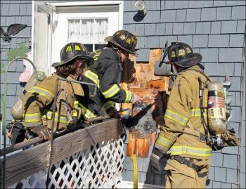 From left, Rockland firefighters Katy Vanorse and Mike Cole and Lt. Jamie Leo work to put out a fire burning outside 10 Frederick St. early Monday afternoon. (Courtesy Rockland Fire Dept./by Alan Athearn)