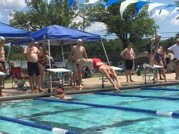 Maine Masters’ 200+ 400-meter medley relay. Susan Rardin (67) finishes breast leg as Brittany Harrington (34) starts fly leg. Drew Darling (65), backstroke swimmer, watches and Dale Syphers (61), anchor free swimmer, awaits turn. Maine Master Ellen O’Donnell observes.