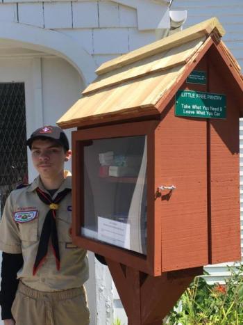 Zachary Dorr, 16, and one of three Little Free Pantries that he conceived and installed as part of the service required to earn his Eagle Scout Badge. The pantry pictured is located at the First Congregational Church in Camden, the same church that sponsors Boy Scout Troop 200. (Photo: Jenna Lookner)