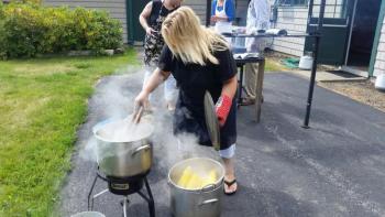 Cathrin Erskine steaming the corn for the buffet lunch. (Photo by Sarah Shepherd)