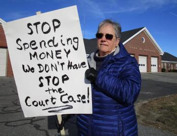 Judy Flanagan, a former Wiscasset select board member and current member of the budget committee, disagrees strongly with the select board’s decision to file suit against the Maine Department of Transportation. “I woke up to the news they filed suit over the Downtown project and felt I had to do something and so here I am,” she said. Flanagan spent Thursday protesting in front of the town office. PHIL DI VECE/Wiscasset Newspaper
