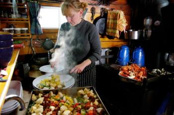 Chef Annie Mahle in the galley of the schooner J. & E. Riggin, prepping a dish. (Photo courtesy Greg Roscoe)
