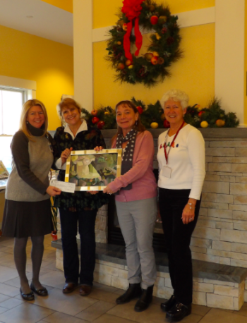 Susan Baines, proprietor of the Kelpie Gallery presents a piece of Erik Lundin's artwork and a check to benefit the Sussman House. Pictured are (left to right) Ellie Willmann, PBMC Foundation; Susan Baines, Kelpie Gallery; Heidi McCaffery, MeHealth Care at Home; and Judy Hengerer, Sussman House Volunteer.