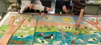 Children point to the creature they created on the Megunticook Watershed ceramic mural they’re working on with artist Randy Fein this winter.
Photo by Randy Fein mural