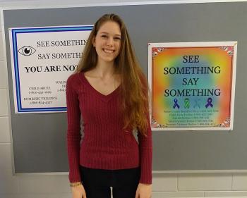 Myah Hatfield standing by her design, the poster on the left. (photo by Erica Thoms)