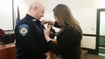 Caitlin Anderson, Thompson’s fiancée, pins the Camden Police Department badge to his uniform at the Select Board meeting. Anderson also works for the town of Camden as the Assistant Assessor. (Photo by Sarah Shepherd)