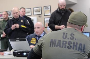 Officers from the state, county, municipal and federal ranks inside the command post, at the Norridgewock Fire Station. (Photo courtesy Maine Office of Public Safety)