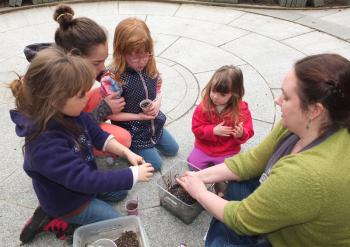 Loraine Murray mixes up a batch of seed-balls for the kids to form.