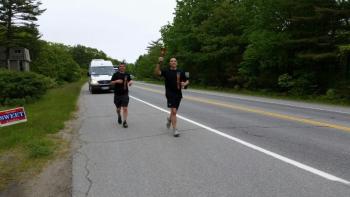 Rockport officer Tony DelVecchio carries the torch on Route 1. (Photo by Sarah Shepherd)