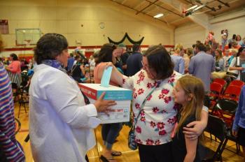 SAD 28 District Superintendent Maria Libby holds a ballot box while a citizen casts her vote. (Photo by Lynda Clancy)