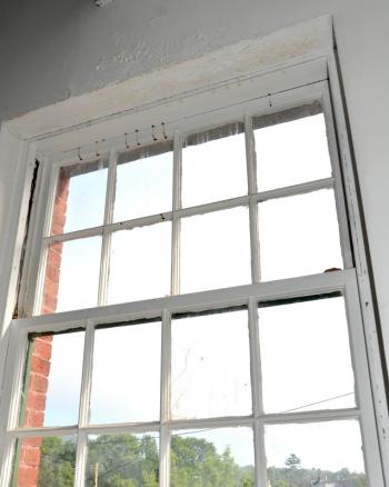 A window in disrepair in the back of the Camden Opera House.