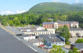 A bird’s eye view over the side of the Camden Opera House roof to Mount Battie. The snow and rain streams down the sides of the steep slate roof, and some collects in the gutters, but instead of draining down the spouts, it leaks through the holes in the gutters and then between the walls and the roof, and eventually inside the Opera House itself. (Photo by Lynda Clancy)