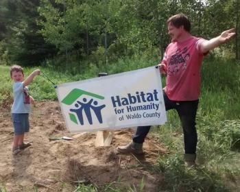 Future homeowner Michael Curtis poses at the site of his new home with his son, Camden, at the July 31 groundbreaking, which was a private event. (photo courtesy of Habitat for Humanity of Waldo County)