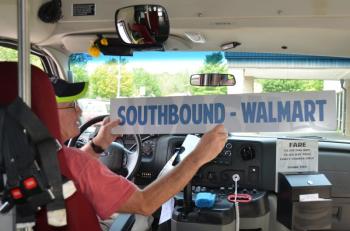 Mike Ray flips the sign that rides in the DASH bus window, letting passengers know that he is heading to Walmart in Thomaston, or back to Pen Bay Medical Center in Rockport. (Photo by Lynda Clancy)