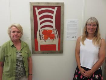 Sherry Reimer, Housing Coordinator , MCH, Inc. and Annette Naegel, Director of Conservation, Georges River Land Trust with oil painting by Bernard Langlais. (Photo courtesy of GRLT)