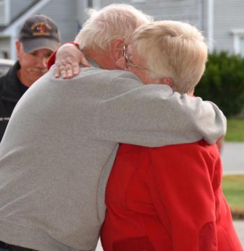 ...But Bruce Woodward returns and gives his wife, Jennifer, a big hug for being complicit in the effort to keep the wool pulled over his eyes as the department planned a party for him. (Photo by Lynda Clancy)