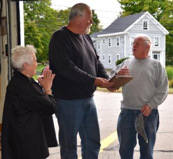 Rockport Select Board members Deb Hall and Mark Kelley honor Bruce Woodward with a plaque and a few jokes for his 50-plus years of service to the town.